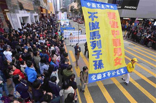 '圖13：遊行隊伍呼籲中國民眾拋棄馬列邪教，做個堂堂正正的中華兒女。'