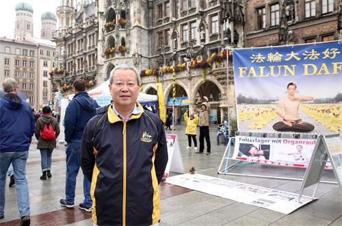 '圖7：前北大經濟學教授夏業良在慕尼黑瑪琳廣場兩次遇到法輪功學員舉辦活動。圖為十月七日夏教授在慕尼黑瑪琳廣場。'