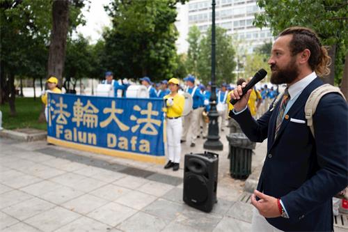 '圖7：二零一九年十月十一日，法輪功學員代表在雅典憲法廣場用希臘文和英文向民眾介紹法輪功和歐洲天國樂團。'