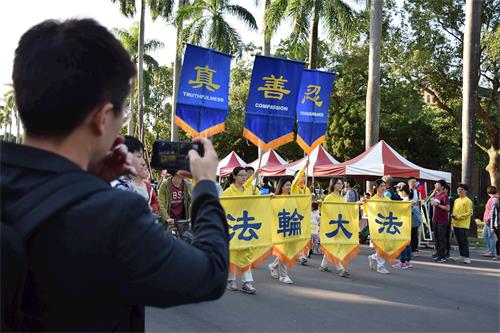 '圖5～7：法輪大法社及天國樂團為下午遊行壓軸隊伍，民眾們紛紛拿起手機拍照留影。'