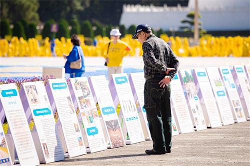 '圖7～10：自由廣場上，法輪功真相展板吸引遊客關注。'