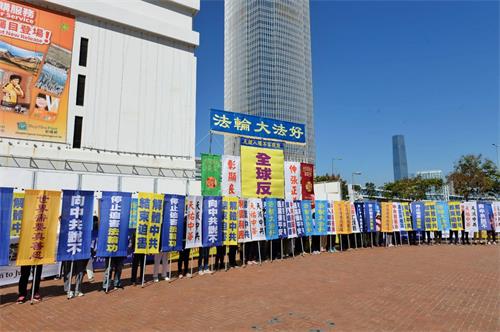 '圖2：法輪功學員在集會上展示各式幡旗，呼籲三退保平安，以及法辦元凶、解體中共。'