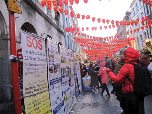 '圖10：二零一九年二月十日晚，一對來自立陶宛（Lithuania）的母女在倫敦唐人街認真了解法輪功真相'