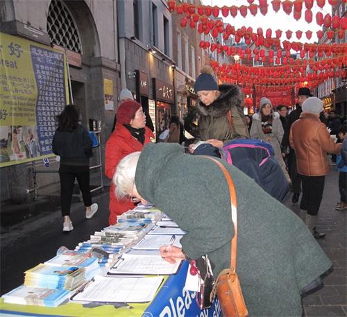 '圖11：二零一九年二月十日，來自位於西班牙和法國之間的巴斯克自治區（Basque Country autonomous community）的埃斯特爾（Estelle）女士（左一）在倫敦唐人街簽名支持法輪功反迫害'