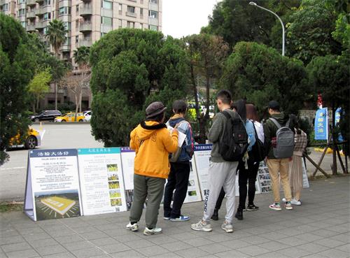 圖7～8：大陸遊客觀看展板內容並聆聽法輪功學員講真相。