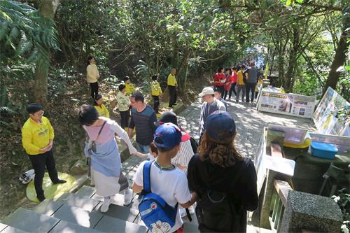 '圖1～2：玄光寺的青龍步道上遊客如織，法輪功學員布置了真相展板，向遊客派送資料，並展示功法。'