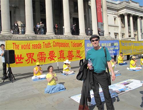 '圖12：美國音樂人大衛﹒哈里斯（David Harris）在特拉法加廣場（Trafalgar Square）北台階認真了解真相後由衷讚歎法輪功。'