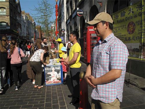 '圖13～14：二零一九年四月二十一日，英國法輪功學員在倫敦唐人街煉功、發傳單講真相，明白真相的民眾簽名支持法輪功學員反迫害'