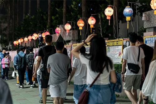 '圖3：慶祝和迎接「世界法輪大法日」的到來，五月十一日華燈初上，法輪功學員們在瑞豐夜市張燈結彩，擺好真相長城，讓路過民眾了解真相。'