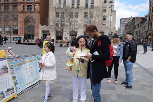 '圖2～6：蒙特利爾法輪功學員聚集在老城兵器廣場（Place D』arms）歡慶世界法輪大法日，慶祝大法弘傳27週年，吸引路人駐足了解真相。'