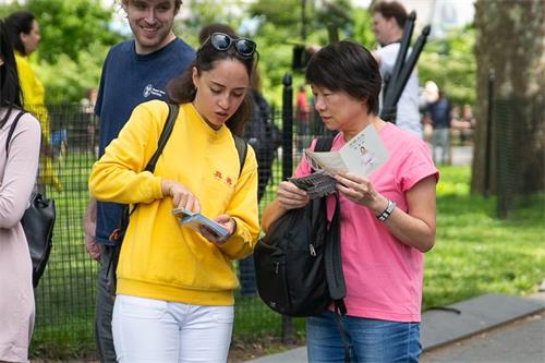 '圖1～6：法輪功學員紐約炮台公園（Battery Park）拉起大型講真相橫幅，並向遊客講真相，人們駐足觀看法輪功學員集體煉功'