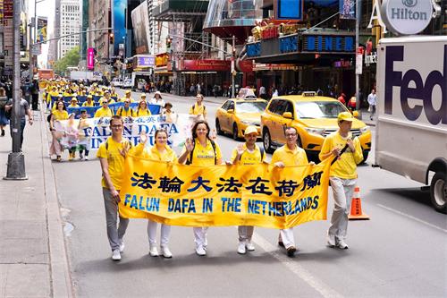 '圖27：哥坎（Goekhan Tunc，前排右三）手持「法輪大法在荷蘭」橫幅走在遊行隊伍中。'