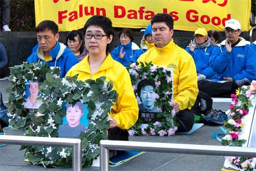 今年四月二十日，法輪功學員王易非手持被迫害致死的妹妹王可非的遺像