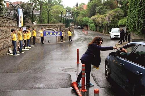 '圖2：法輪功學員向經過領事館的車輛發放真相傳單'