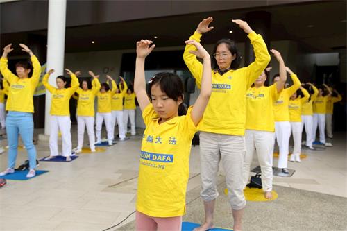 '圖15～16：有不少小同修和爸爸媽媽一起參加煉功。'