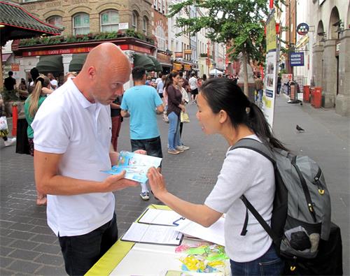 圖7：二零一九年六月一日，斯圖爾德（Steward）在倫敦唐人街聽法輪功學員溫迪講真相後簽名反迫害