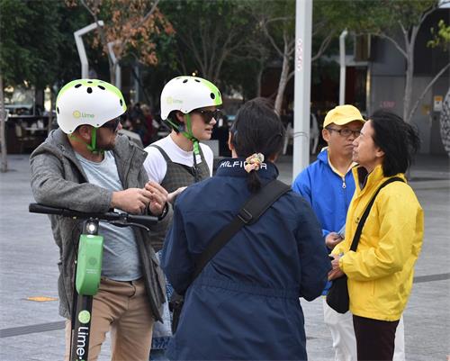 '圖5：大學藝術系學生阿曼達（左二）和同伴安東尼（左一）在聽法輪功學員講述迫害'