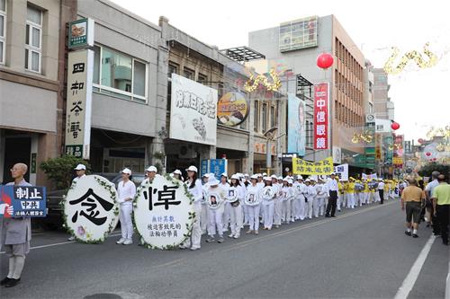 '圖7：學員衣著淨白素服，手捧被迫害致死的大陸法輪功學員照片，聖潔靜肅行進。'