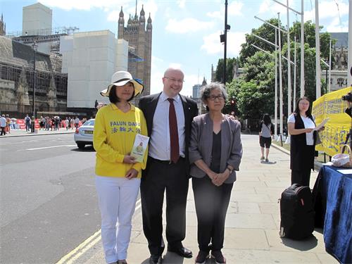 '圖11：帕特裏克﹒格雷迪國會議員（Patrick Grady MP）在法輪功學員「反迫害二十年」集會現場與來自他選區的法輪功學員合影'