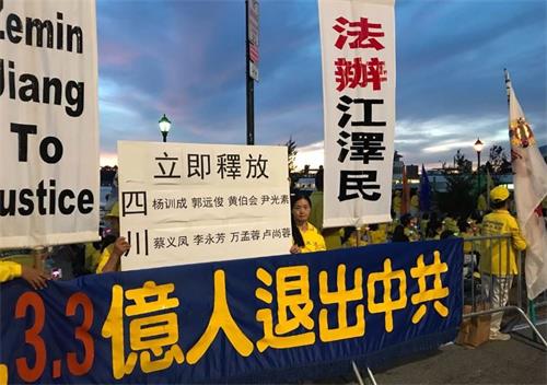 '圖9：來自四川的法輪功學員常小春打出展板，要求立即釋放四川省綿竹市多名法輪功學員，法辦迫害元凶江澤民。'