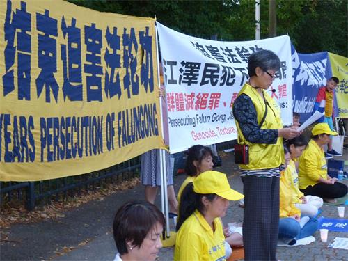 '圖9：法輪功學員魏再群女士在中共駐丹麥使館前講述因為修煉法輪功，國內親人家破人亡，她自己在丹麥遭受中使館報復迫害的經歷'