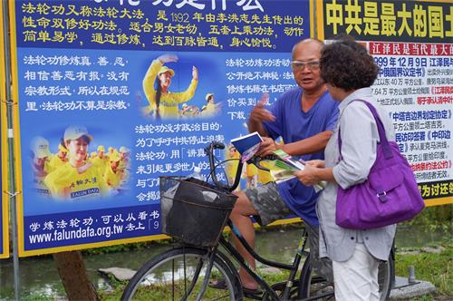 '圖10～13：二零一九年七月二十日，高雄法輪功學員聚集在鳳凌廣場，舉行法輪功反迫害二十週年集會活動。圖為真相圖片展、反迫害徵簽。不少過往民眾駐足關注。'