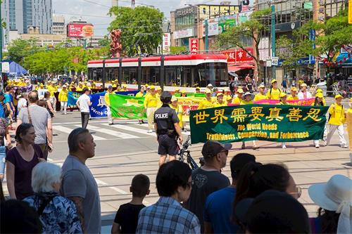 '圖3：2019年7月20日，加拿大東部法輪功學員彙集多倫多市中心，舉行盛大遊行，紀念反迫害20週，呼籲中共停止對法輪功修團體的迫害。'