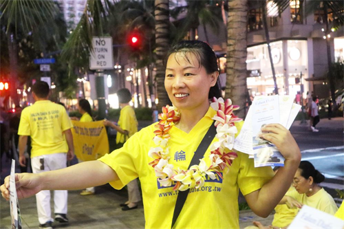 '圖6：法輪功學員佩戴明真相的民眾贈送的雞蛋花花環向過往遊客發資料'