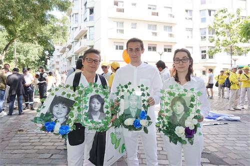 '圖2：勞倫斯（右）和女兒、兒子都是開始修煉不久的新學員，他們都體驗到修煉真善忍的美好，加入到揭露迫害的隊伍。'