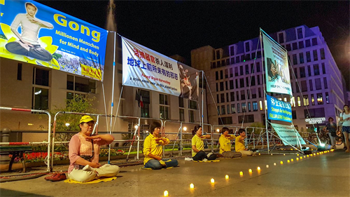 '圖5：法輪功學員們在燭光下演示功法'