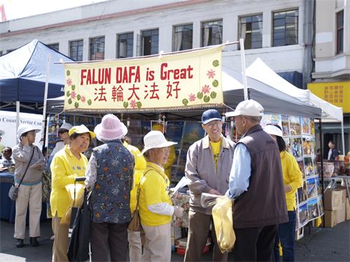 圖1：二零一九年八月二十四日，法輪功學員在北加州奧克蘭中國城中秋街會上擺放攤位，傳播真相。前來了解真相的人們絡繹不絕。