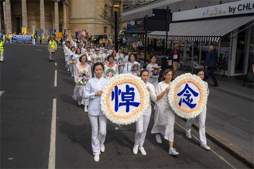 '圖1：千名法輪功學員倫敦大遊行，圖為悼念被中共迫害致死的法輪功學員的方陣。'