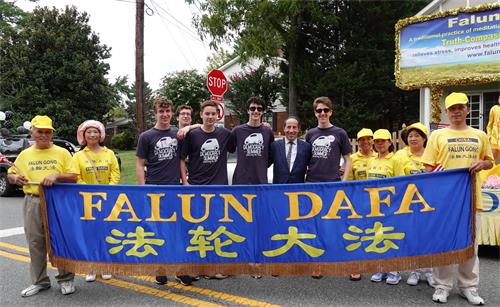 6：美國馬裏蘭州聯邦眾議員拉斯金（Jamie Raskin)（左七）在遊行終點處與法輪功學員合影。