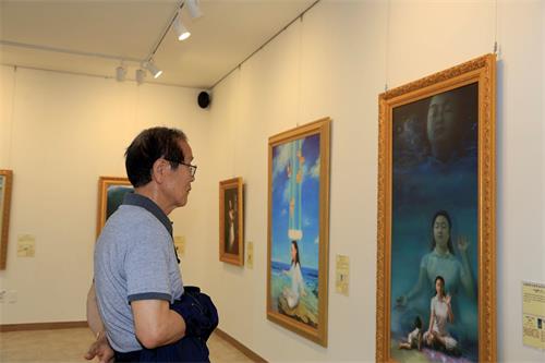 '圖9：77歲的姜明德先生很高興通過「真善忍國際美術展」了解到了修煉身心的法輪功，他對修煉產生了興趣。'