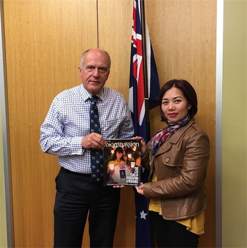 '圖：澳洲聯邦參議員、參議院外交事務委員會主席阿貝茨先生（Senator the Hon Eric Abetz，左）在其位於塔斯曼尼亞州首府霍巴特市中心的辦公室和法輪功學員合影。'