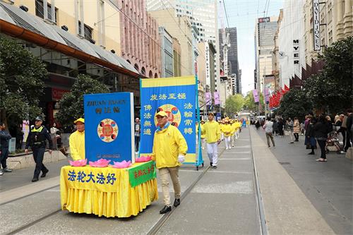 '圖2：2019年10月11日，約五百名法輪功學員在墨爾本市中心舉行盛大遊行，向澳洲民眾展現法輪大法的美好。圖為《轉法輪》書模。'