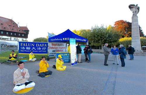 '圖1：法輪功學員在康斯坦茨（Konstanz）地標康斯坦茨港口齊柏林紀念碑（Zeppelin－Denkmal）前舉辦活動。'