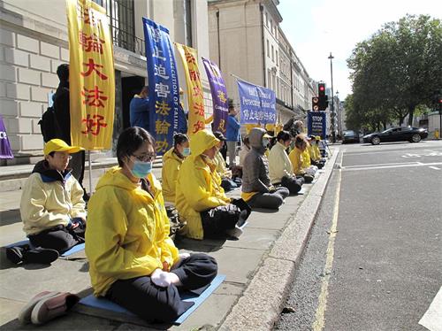 '圖1～2：二零二零年十月一日，英國法輪功學員在倫敦中使館前舉行反迫害活動，吸引過往民眾關注，支持法輪功反迫害。'