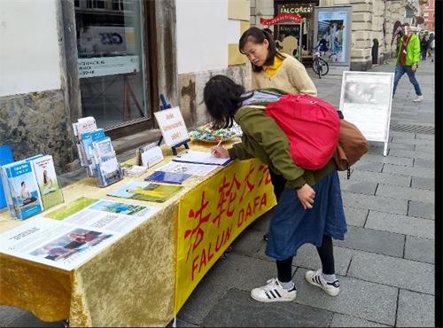 '圖5：一位來自台灣了解真相的女士來到展位前簽字並表達她對法輪功的支持'