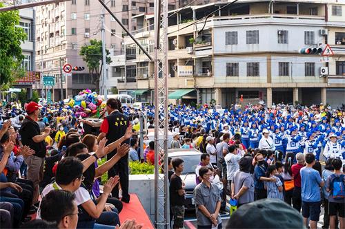 '圖1～2：氣勢磅礡的法輪功天國樂團非常吸睛，遊行隊伍浩浩蕩蕩穿行岡山熱鬧市，經過主席台時，很多政要揮手致意，沿途吸引不少民眾觀看、比讚和拍照。'