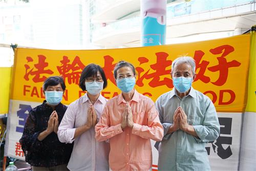 圖：香港真相景點講真相法輪功學員感恩法輪功創始人李洪志先生洪傳大法（左一為鄭小姐，左三為小王）。