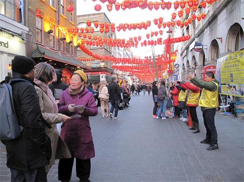 '圖1～3：二零二零年二月一日，英國法輪功學員在倫敦唐人街煉功、發放資料、講真相、徵簽反迫害，民眾駐足了解真相，簽名支持法輪功。'