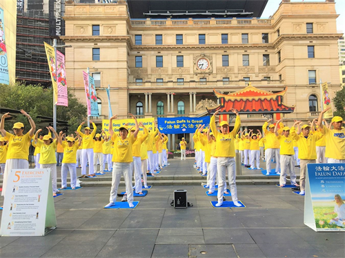 '圖1：法輪功學員在悉尼市中心海關大樓前展示法輪大法五套煉功功法。'