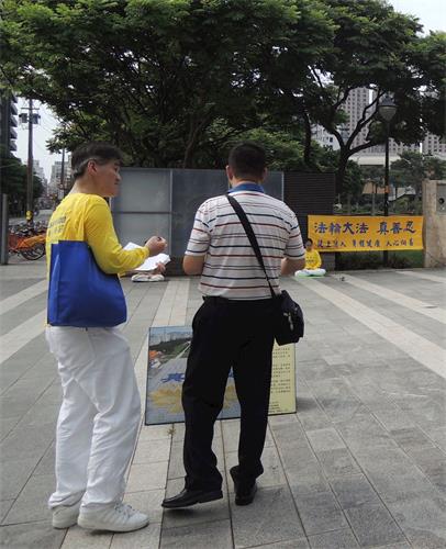 '圖10：中正公園埔子圖書館煉功點學員向民眾講真相。'