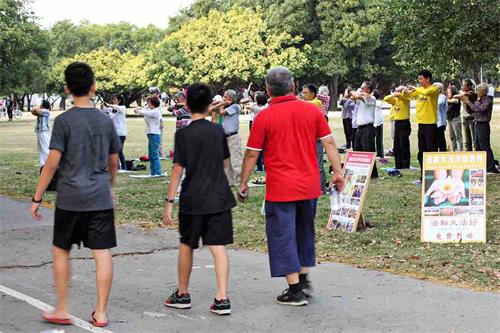 '圖4：高雄學員分批分地舉辦慶祝活動，在鳳山衛武營向民眾展示祥和優美的五套功法，吸引不少散步的民眾駐足觀看，了解真相。'