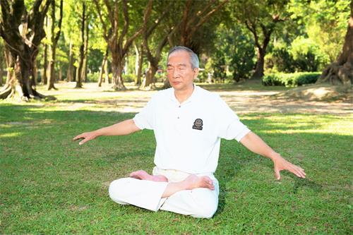 '圖1：李育寬早上至公園晨煉，正在煉法輪功第五套功法。'