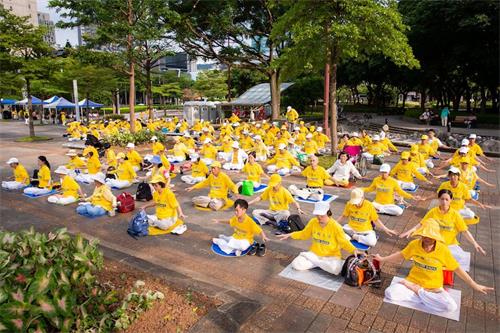 '圖15：台北市市府廣場旁草地上還有二百多人展示法輪功五套優美功法。'