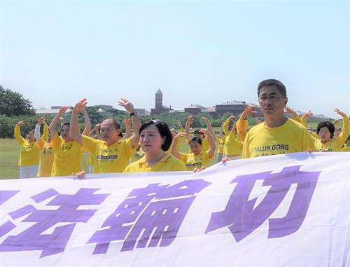 '圖13：美國華府法輪功學員薛斌（右一）在華盛頓紀念碑前的「七.二零」反迫害活動現場。'