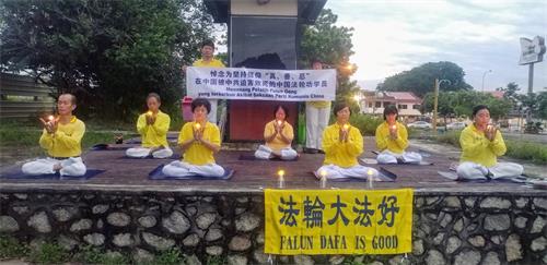 '圖10：七月十八日早上，柔佛州新山彩虹花園（Taman Pelangi）的部份法輪功學員在煉功點舉行悼念活動，希望更多的民眾能了解真相。'