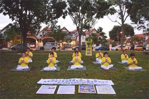 '圖11：七月十九日早上，柔佛州新山開屏花園（Taman Pelangi Indah）的部份法輪功學員在煉功點舉行悼念活動，希望更多的民眾能了解真相。'